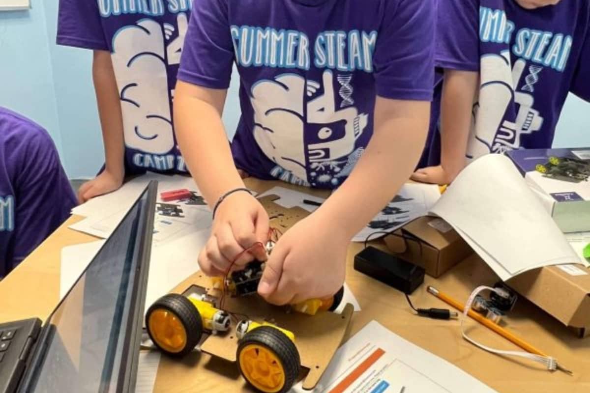 Camper learning about robotics with toy car at Tip Top Brain